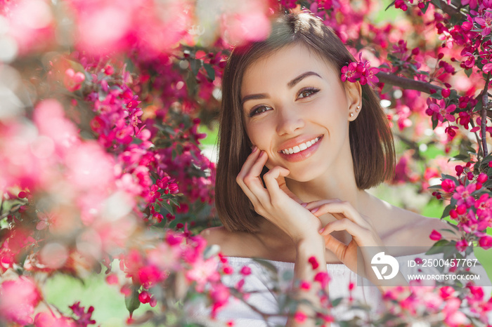 Beauty portrait of young woman closeup. Attractive female in flowers with copy space. Beautiful lady