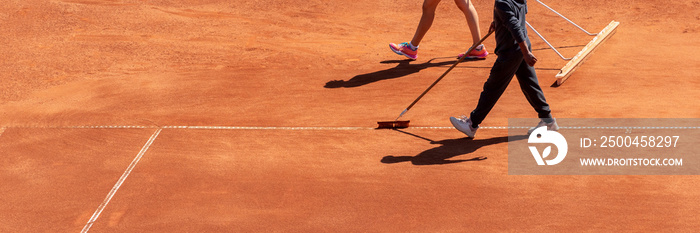 Clay tennis court cleaning after match. Maintenance and preparation surface of orange sport ground f