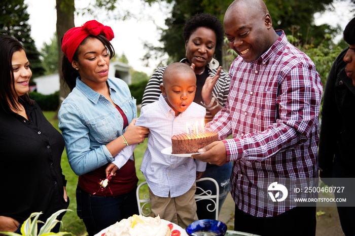 Boy blowing birthday cake candles