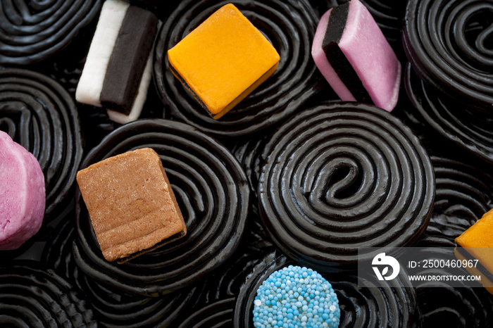 Black liquorice swirls, chewy candy and delicious dessert concept with macro close up on licorice wh