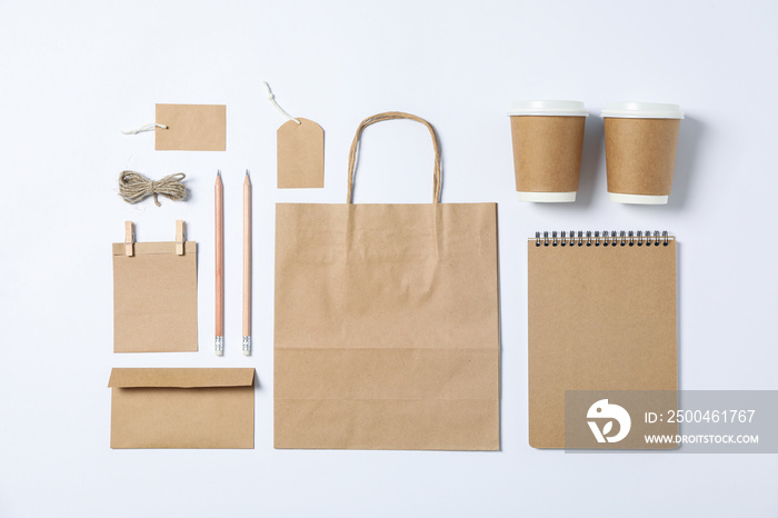 Flat lay composition with blank stationery, paper cups and bag on white background, mockup