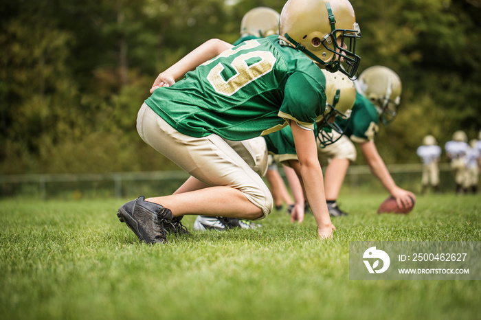 Side view of boys playing American football in field