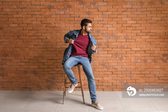 Fashionable young man near brick wall