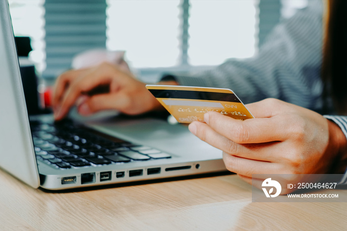 Woman customer hands holding credit card and using laptop for online shopping, online payment concep