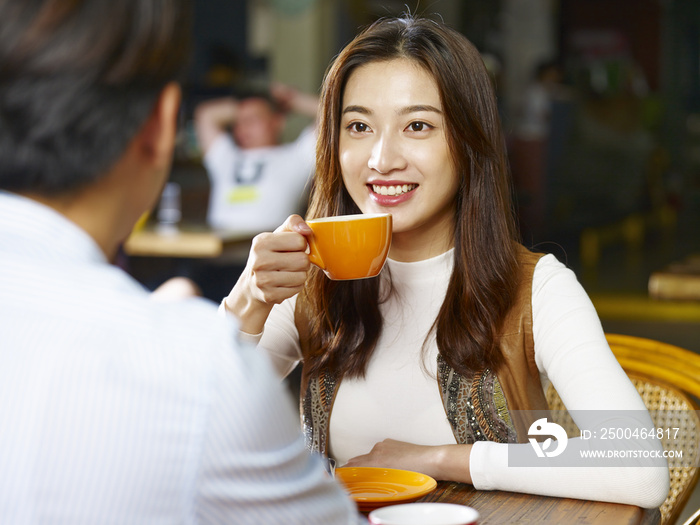 young asian couple talking face to face in coffee shop