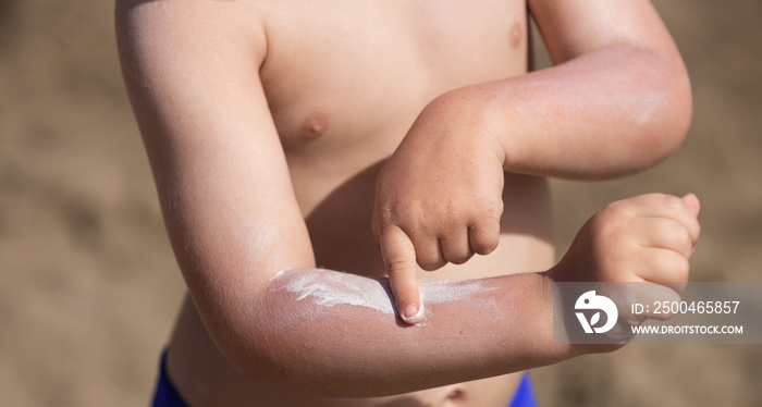 防晒系数SPF的防晒霜。男孩使用防晒霜。太阳能辐射会导致晒伤