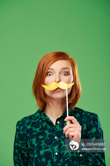 Portrait of playful woman with mustache in studio shot
