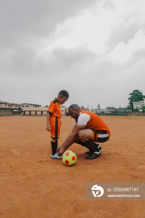 Son watches father as he ties shoelace