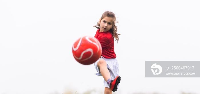 Little girl kicks soccer ball