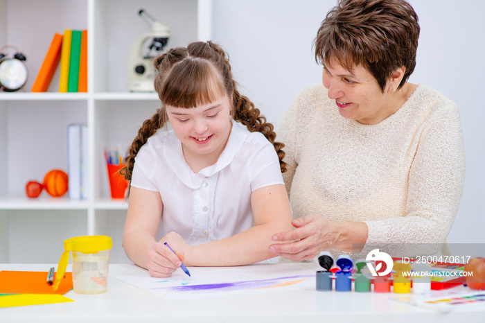Mom deals with a girl with Down syndrome. The concept of home schooling and classes. Mother and daug