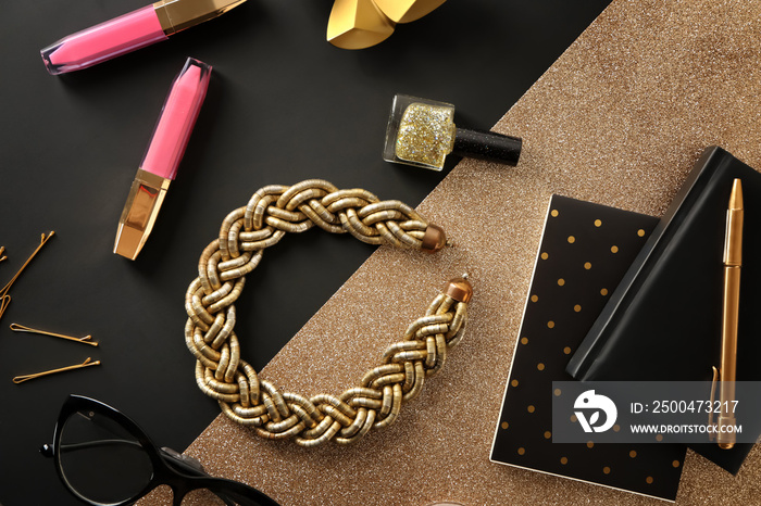 Flat lay composition with cosmetics and accessories on black and golden background