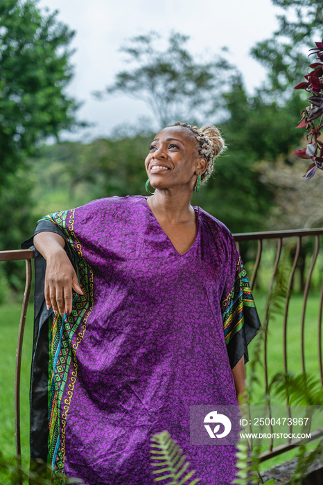 Retrato vertical de una hermosa mujer afrocaribeña muy sonriente en el exterior de su casa disfrutan