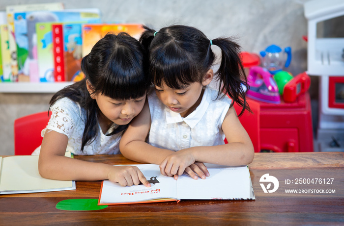 Portrait of pupils looking at page reading lesson