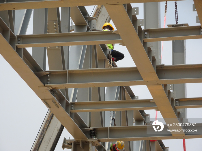 建筑工人在高空作业安装钢结构。钢结构能够提供