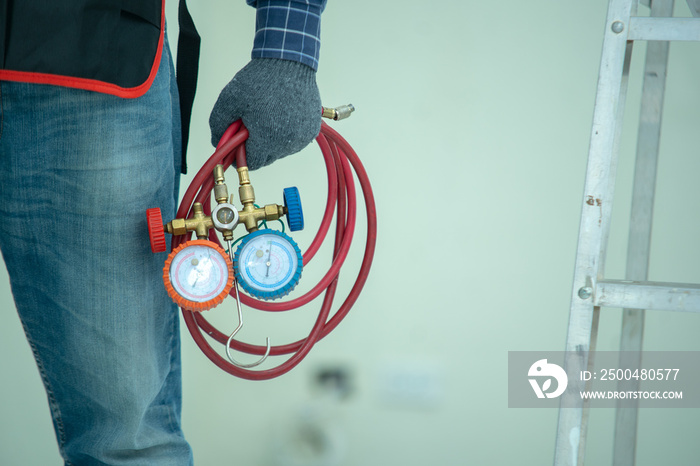 The technician is checking the air system,measuring equipment for filling air conditioners.