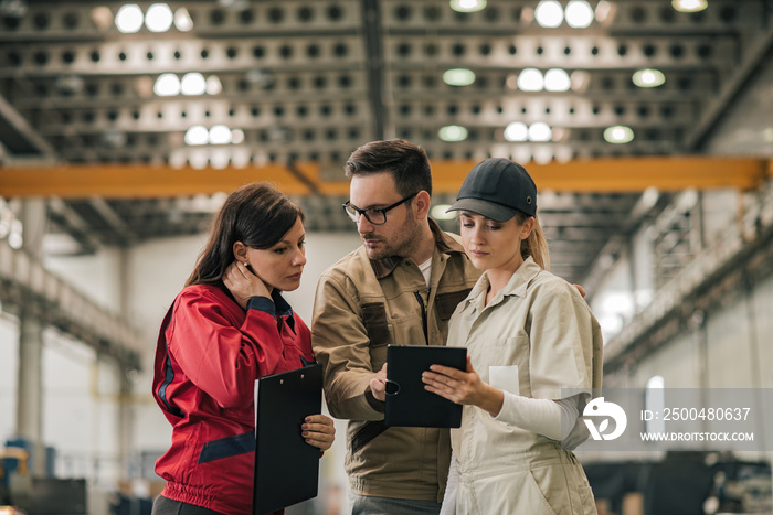 Team of factory engineers and workers discussing work.