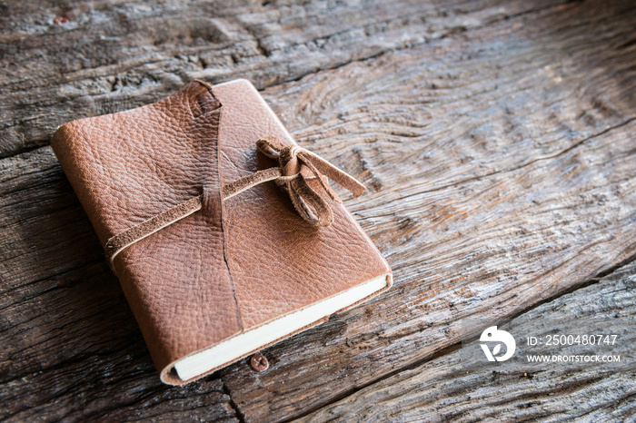 The leather book on the wood table.