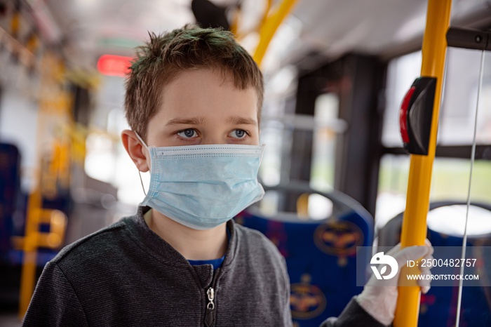 Child in protective mask travelling by public bus