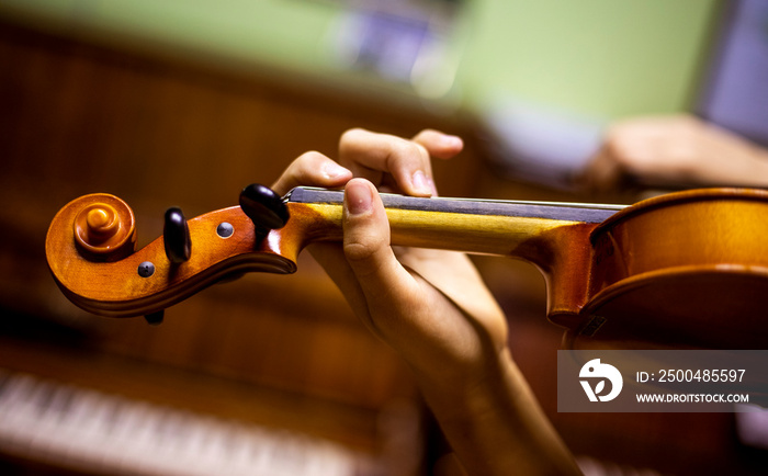 left hand of a young violinist holding the fretboard while playing violins, goizontal