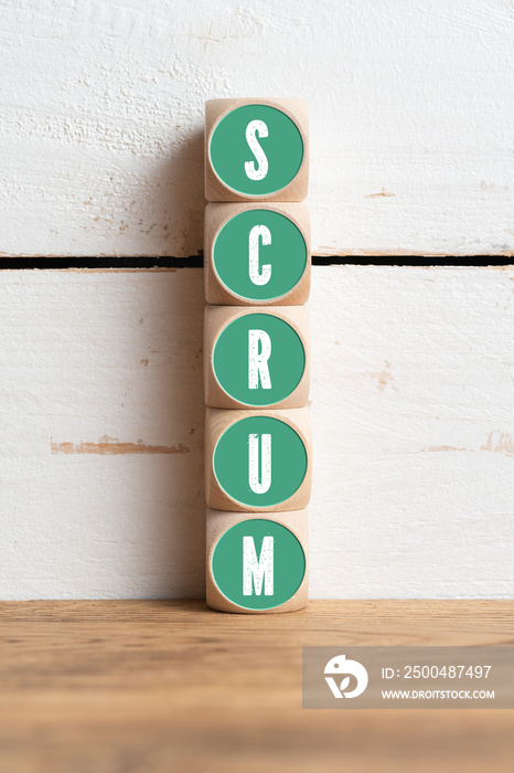 cubes with message SCRUM in front of wooden background