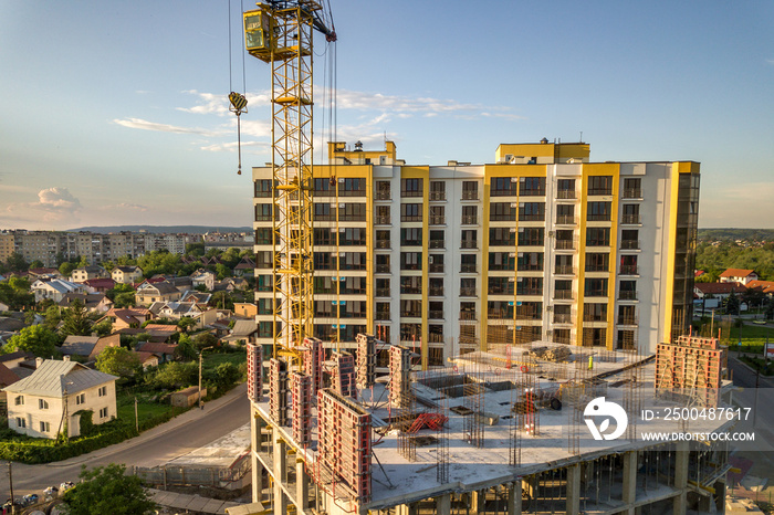 Apartment or office tall building under construction. Brick walls, glass windows, scaffolding and co