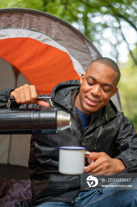 Man pouring hot drink from insulated bottle?