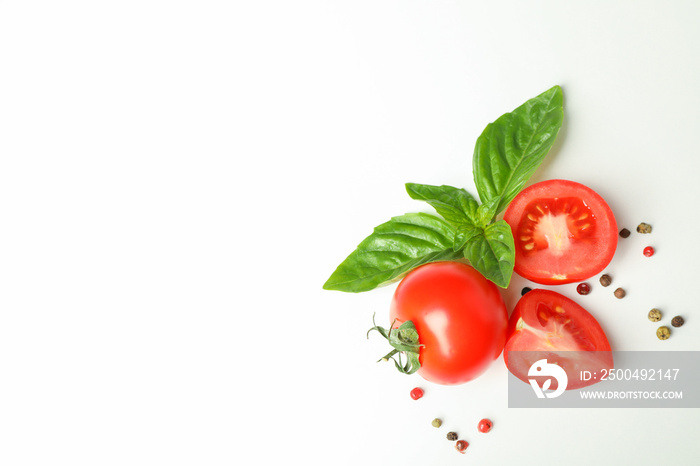 Fresh cherry tomatoes with basil and spices on white background, space for text and top view. Ripe v