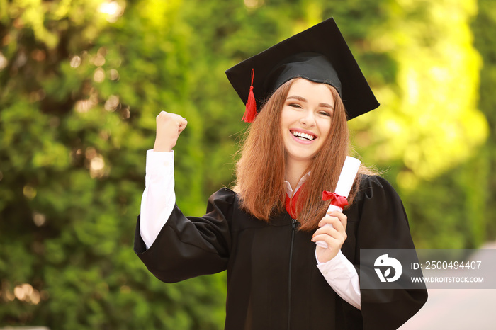 Happy young woman with diploma on graduation day