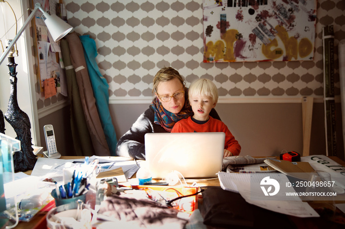 Mother with son using laptop at home