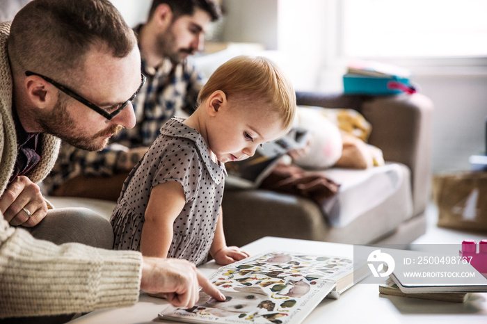 Father and daughter looking at book