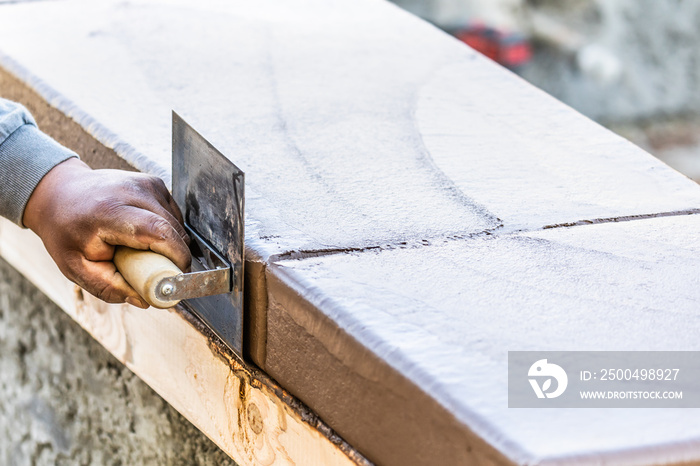 Construction Worker Using Stainless Steel Edger On Wet Cement Forming Coping Around New Pool