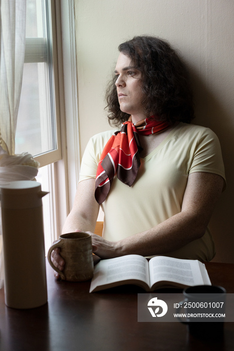 portrait of transgender woman sitting by window