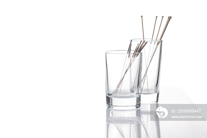 Silver needles for traditional Chinese acupuncture medicine. White background.