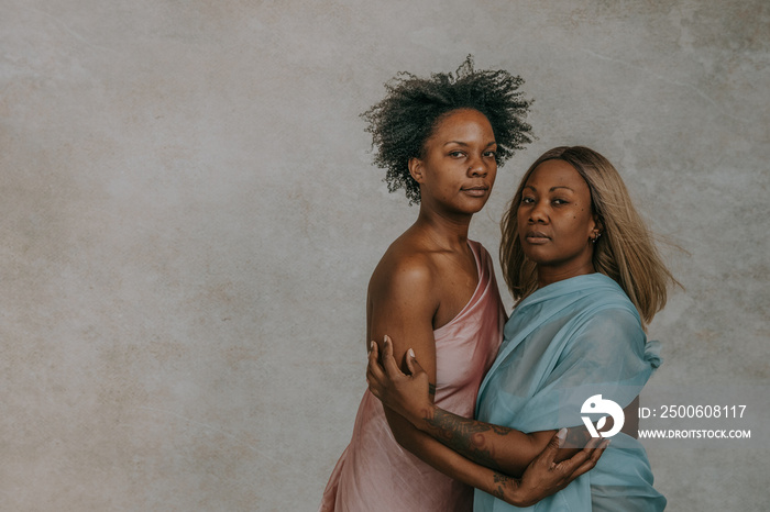 2 African American women hugging looking at camera