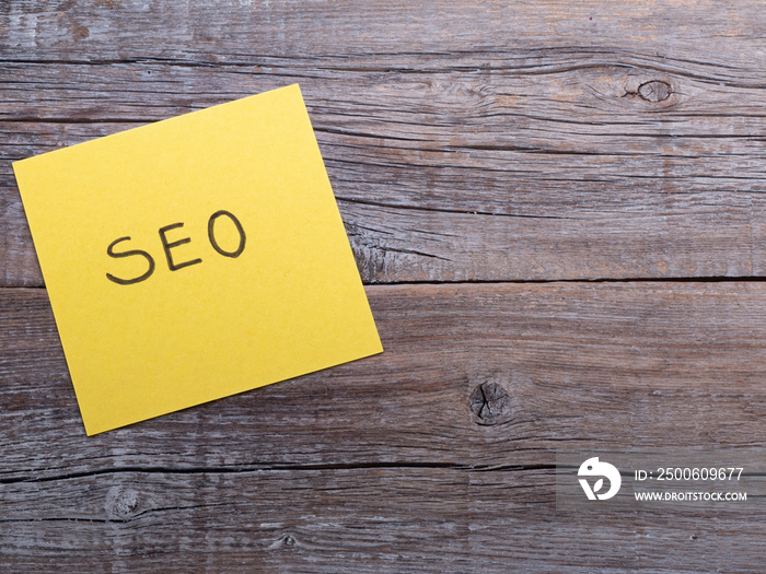 Handwriting text writing SEO. Plain note paper on the top of wooden table desk.