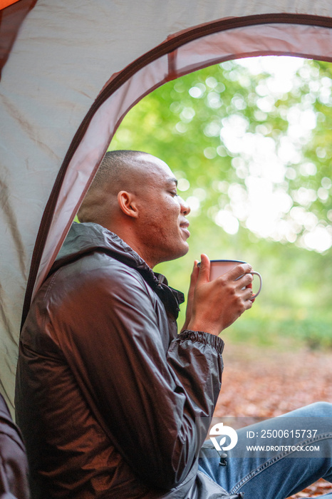 Man enjoying warm drink in tent?