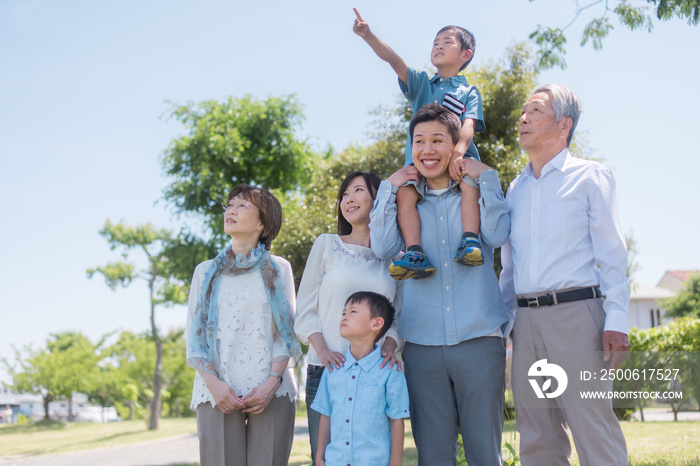 公園で息子を肩車するお父さんと三世代家族