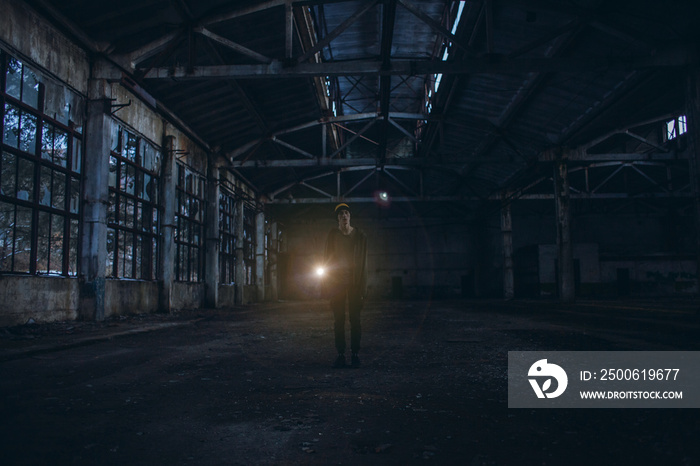 Lonely Boy with a Flashlight Walks in an Abandoned Room