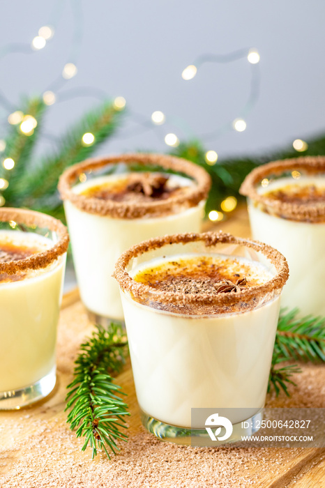 Eggnog with cinnamon and nutmeg for Christmas and winter holidays. Homemade eggnog in glasses on woo