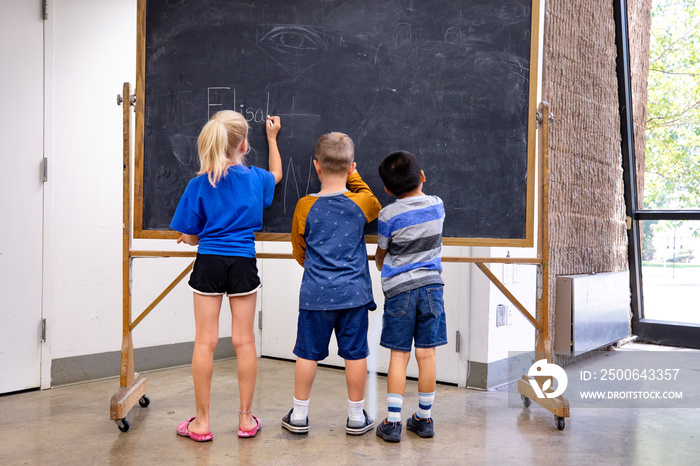 Children writing on a chalkboard