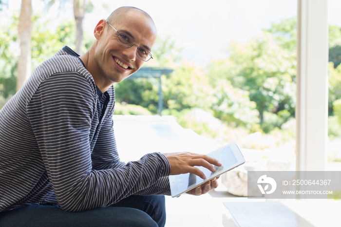 Portrait smiling man using digital tablet