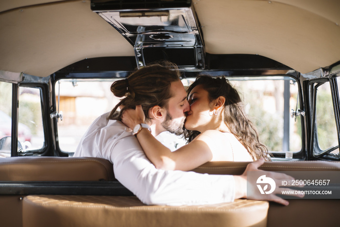 快乐的年轻情侣坐在面包车里