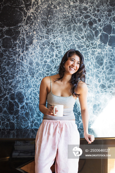 Smiling young woman holding mug