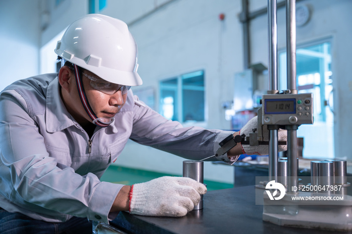 Asian technician worker wearing a safety suit and Quality Checking with hight gauge mass Product on 