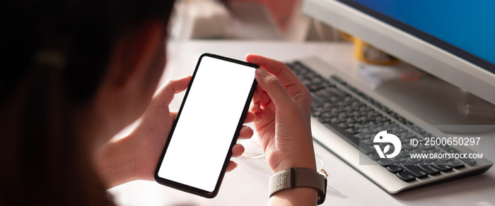 Hand of woman using smartphone over workplace