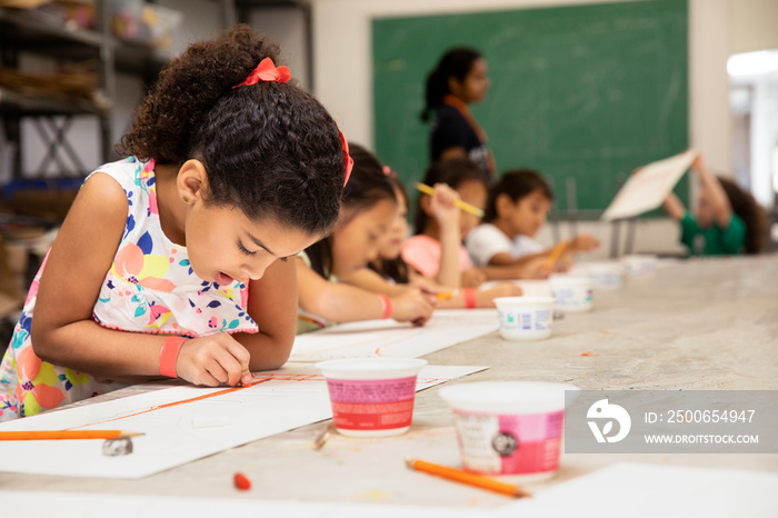 Young girl drawing in a classroom