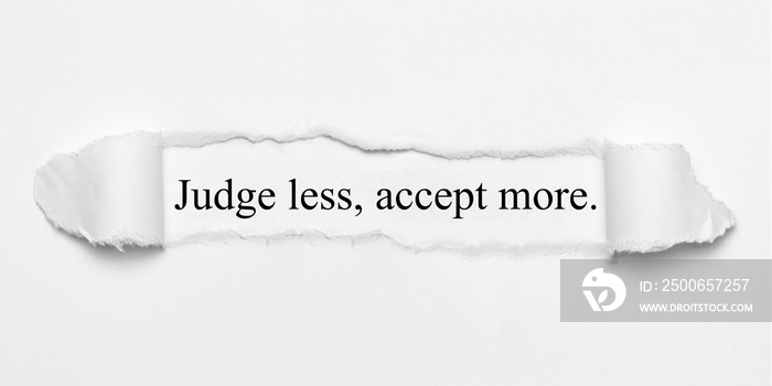 Judge less, accept more. on white torn paper