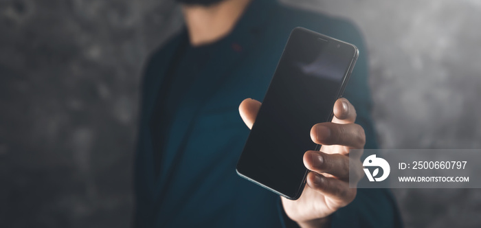 man hand smart phone on dark abstract background