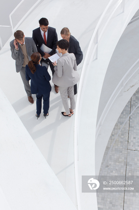 Business people talking in circle on ramp