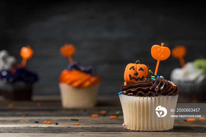 Cupcake on Halloween party. Dessert decorated with colored frosting, Icing and chocolate cream. Carv